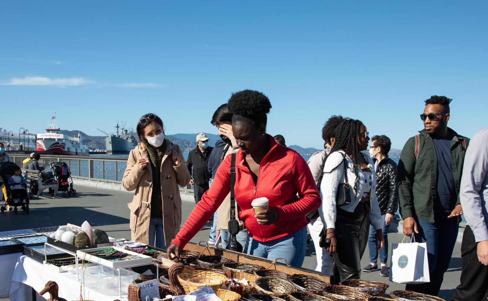 People shopping at a street vendor's table at Fisherman's Wharf