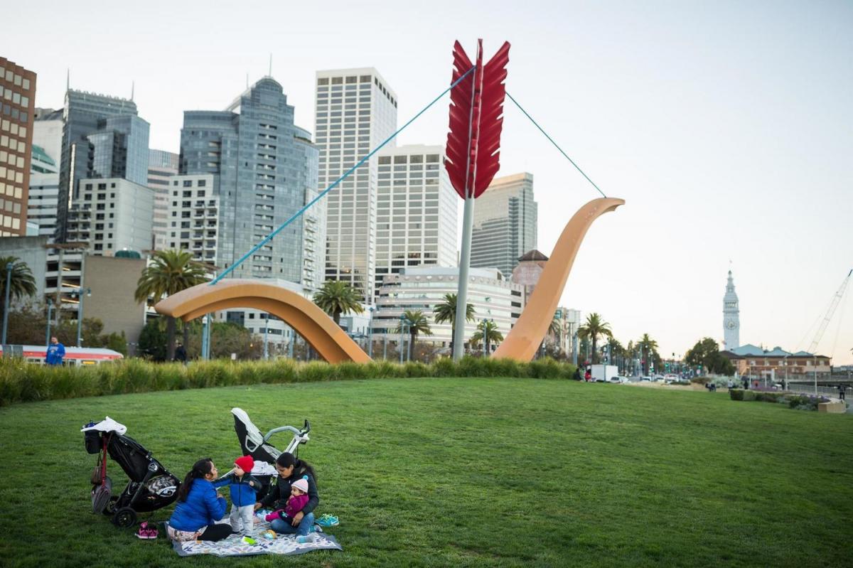 A small family enjoys a picnic on the lawn underneath Cupid's Bow.