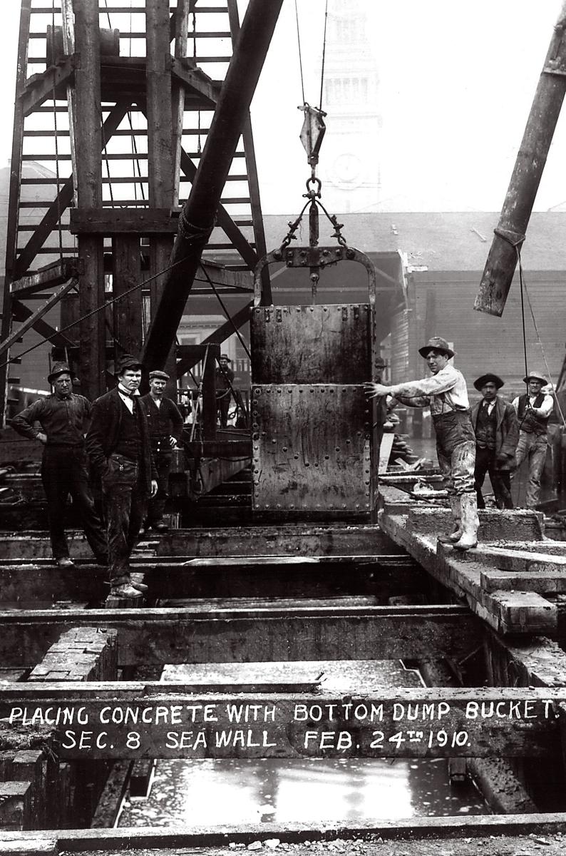 Historic&nbsp;image&nbsp;of&nbsp;workers&nbsp;placing&nbsp;a&nbsp;concrete&nbsp;bucket&nbsp;into&nbsp;the&nbsp;seawall,&nbsp;circa&nbsp;1910.&nbsp;