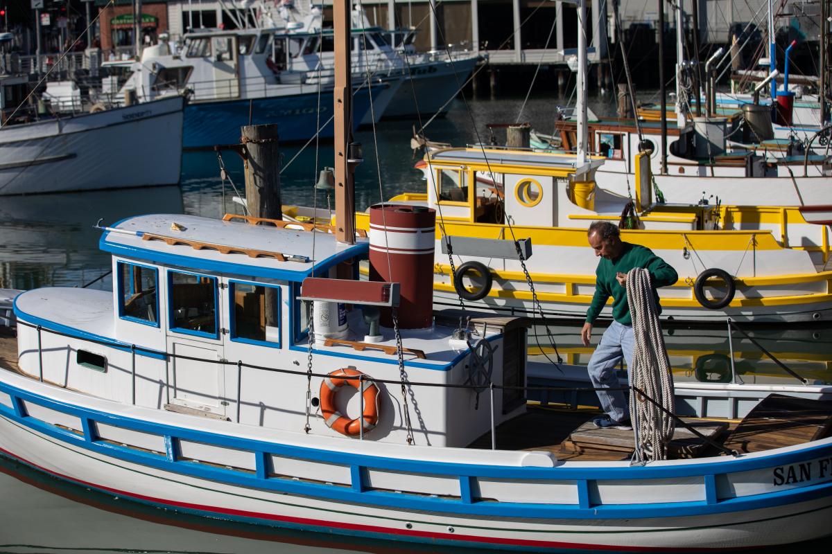 Fisherman&nbsp;with&nbsp;ropes&nbsp;standing&nbsp;on&nbsp;top&nbsp;of&nbsp;a&nbsp;Monterey&nbsp;boat.&nbsp;