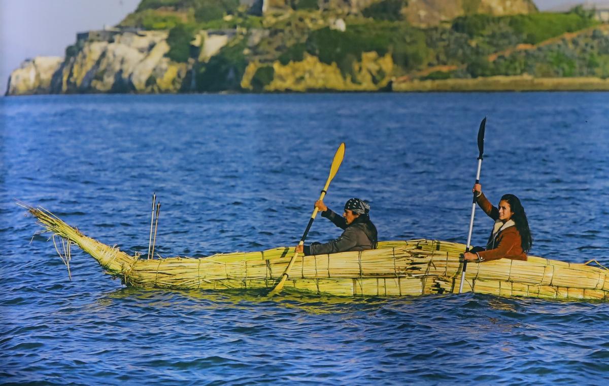 Modern Ohlone community members paddle a tule boat in front&nbsp;of&nbsp;Alcatraz.&nbsp;