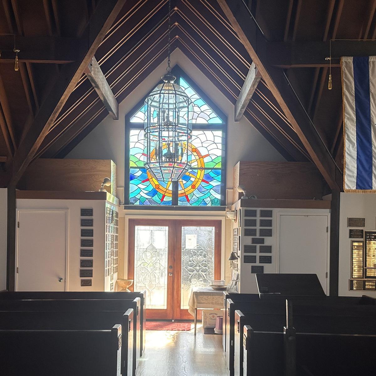 Interior of Fishermen’s and Seamen’s&nbsp;Memorial&nbsp;Chapel,&nbsp;featuring&nbsp;stained&nbsp;glass&nbsp;windows&nbsp;and&nbsp;plaques.