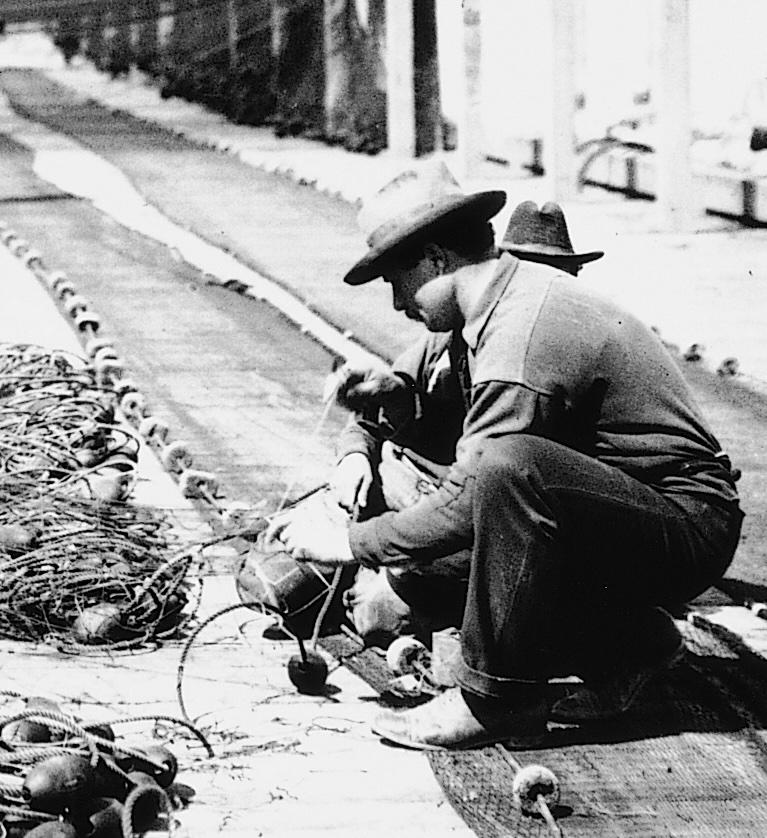 Men wearing 1930s clothing mending nets. 