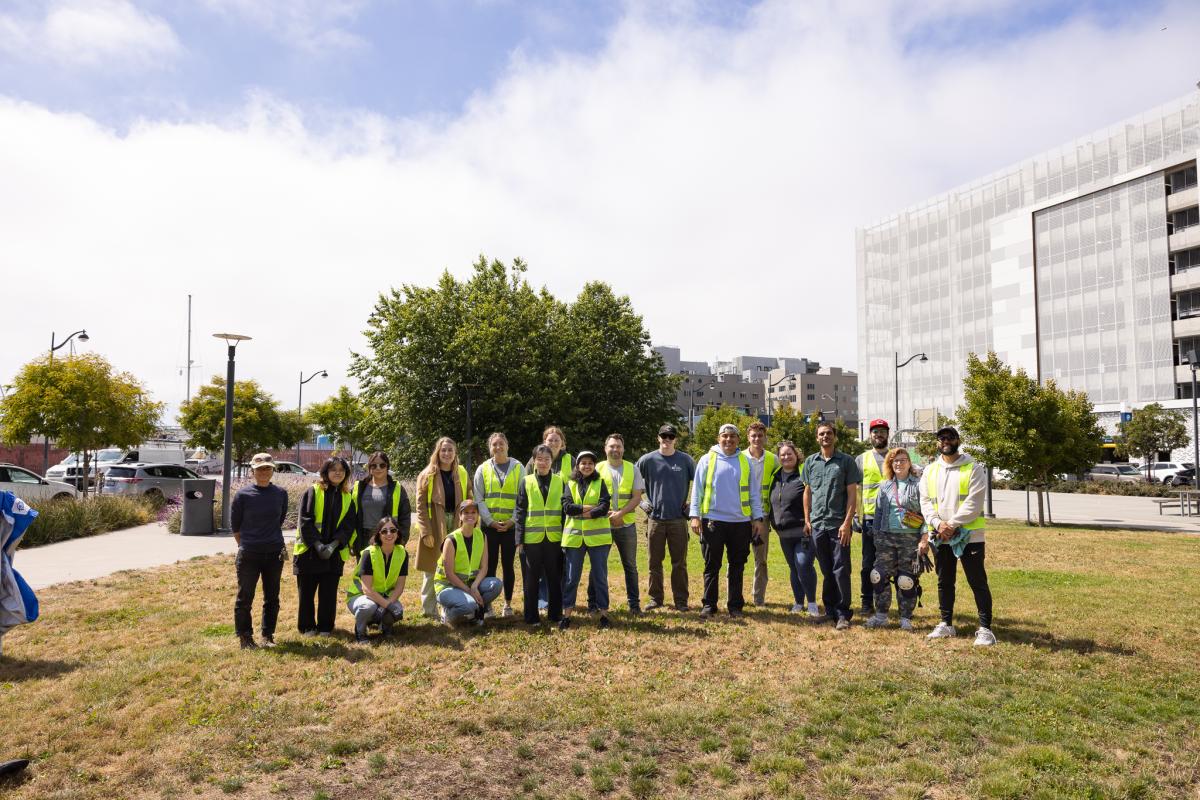 Group of people pose for photo on grass.